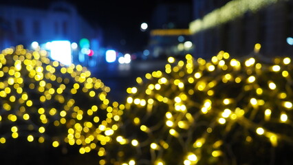 Bokeh city Christmas New Year glowing golden garland. Outdoor winter decoration. Festive design of town square. Bokeh flickering light bulbs. Festival Noel xmas good mood. Defocused Sremska Mitrovica