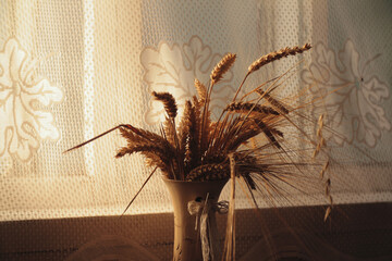 View of bunch stems with ears of wheat in vase. High quality photo