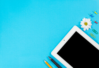 Office stationery and tablet on a blue background, office stationery
