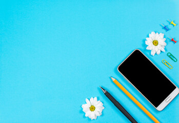 Office stationery and mobile phone on a blue background, office stationery