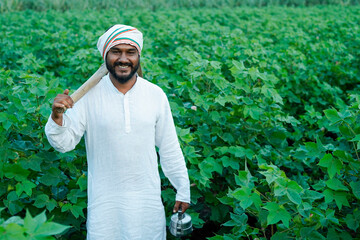 Beautiful portrait of Indian rural farmer standing in the field wearing kurta pajama, looking into...