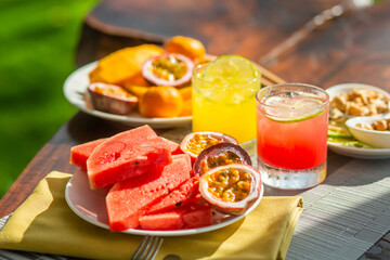 A vibrant display of fresh sliced fruits and refreshing juices on a sunlit table evoking a perfect summer vibe.