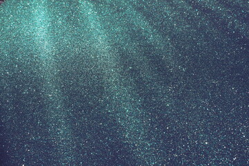 Oblique rays of light on a blue surface. Bokeh, dust particles, reflection and magical glow....
