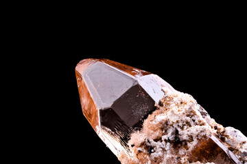 imperial topaz crystal isolated on black background. macro detail close-up rough raw unpolished semi-precious gemstone.

