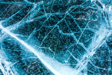 Top vies of a texture cracks transparent ice on a Baikal lake on a snowy winter day 