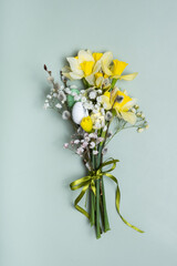 Easter spring bouquet with daffodils and willow on green background. Easter greeting card