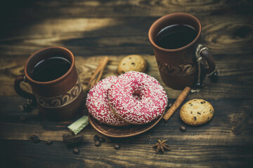 Beautiful mug with coffee and pink donuts on a beautiful background, holiday treats