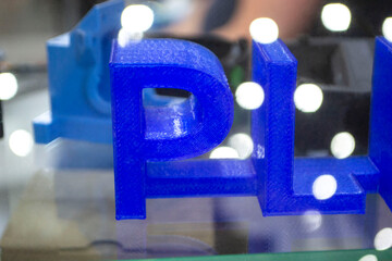 Objects letters printed on 3D printer close-up. Models letter 3D printed from molten plastic blue color. FDM technologies. Additive progressive modern new technology. 3D printing innovation technology