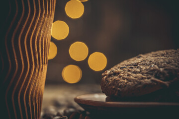 Paper cup with coffee and chocolate cookies on a beautiful background, holiday treats