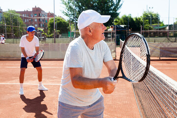 Grandfather and grandson playing tennis court