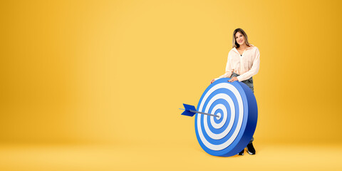 Woman standing near dartboard with arrow hit the center, copy space