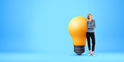 Thoughtful woman and big light bulb