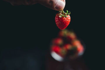 Healthy love concept, strawberry fruit on glass, black background.
