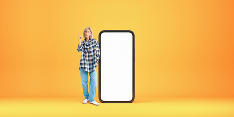 Woman pointing up near big phone