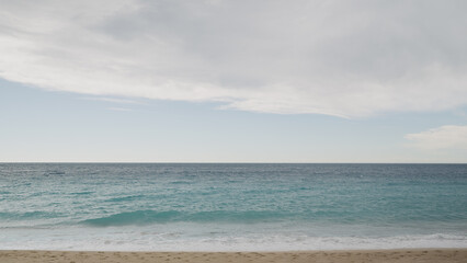 Clear blue waves with strong wind on a sandy empty beach in Cannes in spring