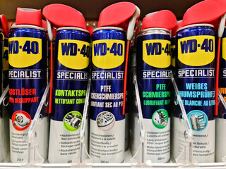 Kiel, Germany - 12 December 2023: A row of cans of WD-40 rust remover on a DIY store shelf
