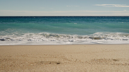 Fototapeta na wymiar blue waves on a sandy empty beach in Cannes in spring