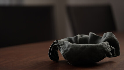 Empty blue ceramic bowl with linen napkin on walnut wood table