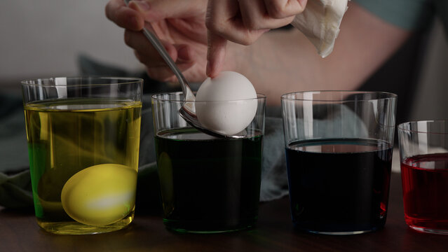 Man painting eggs for easter with various colorings