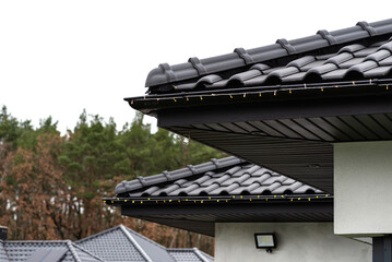 Installing LED lights along the gutter around the house, decorating the house for the holidays.