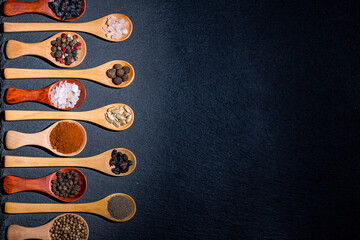 All types of spices on a black background, different spices in spoons on a black background,...