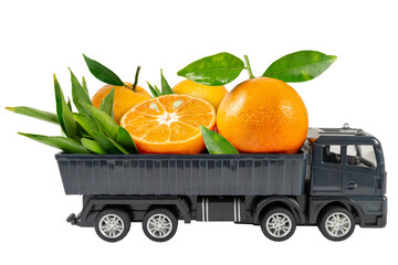A miniature toy truck delivering ripe yellow tangerines with green leaves. Food delivery concept.
