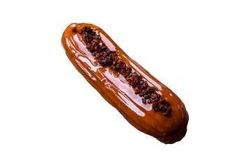 Delicious fresh eclair with chocolate cream on a black ceramic plate
