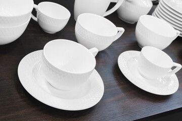 selective focus of different plates, cup, bowl  on dark wooden table, hotel service breakfast concept