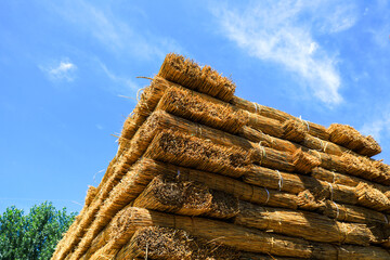 Piles of reed curtains against a blue sky background