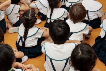 Group of elementary school students sitting on the floor in the classroom.