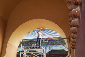 Beijing, China - July 21, 2022: Workers are repairing the gate of the Prayer Hall in the Temple of...