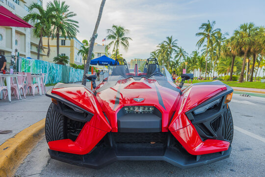 Front view of a parked red Polaris Slingshot on Ocean Drive in Miami Beach. USA. 