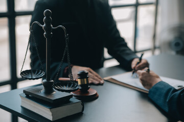 Justice and law concept.Male judge in a courtroom with the gavel, working with, computer and...