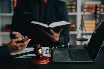 Justice and law concept.Male judge in a courtroom with the gavel, working with, computer and docking keyboard, eyeglasses, on table in morning light - obrazy, fototapety, plakaty