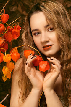 Girl with fesalis. A girl and a natural bouquet of orange dried flowers. The girl holds a fesalis in her hands. The girl holds dried flowers in her hands.