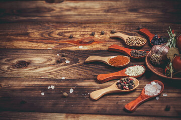 Many different spices and vegetables on a wooden table, aromatic spices and fresh vegetables for...