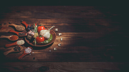 Many different spices and vegetables on a wooden table, aromatic spices and fresh vegetables for cooking, a variety of spices