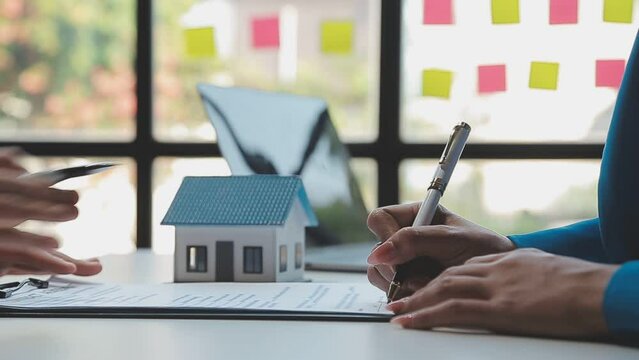 Real estate broker agent being analysis and making the decision a home estate loan to customer to signing contract documents for realty purchase, Bank employees recommend mortgage loan approval.