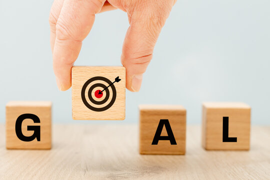 Goal symbol A raised dice with a target and an arrow in the middle, forming the word "goal". Beautiful blue background. Business concept, setting and following a goal, copy space