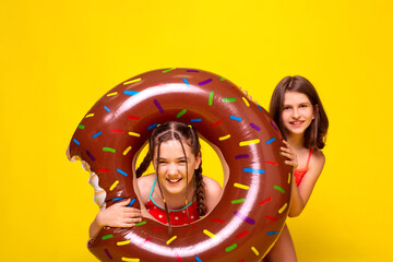 girl face look through large brown inflatable ring isolated yellow background