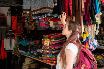 Mujer turista mirando los artículos de una tienda de recuerdos en Salta, Argentina	
