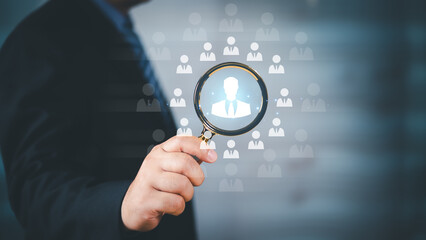 HRM or Human Resource Management, Businessman holding Magnifying glass focus to manager icon which is among staff icons for human development recruitment leadership and customer target group concept.