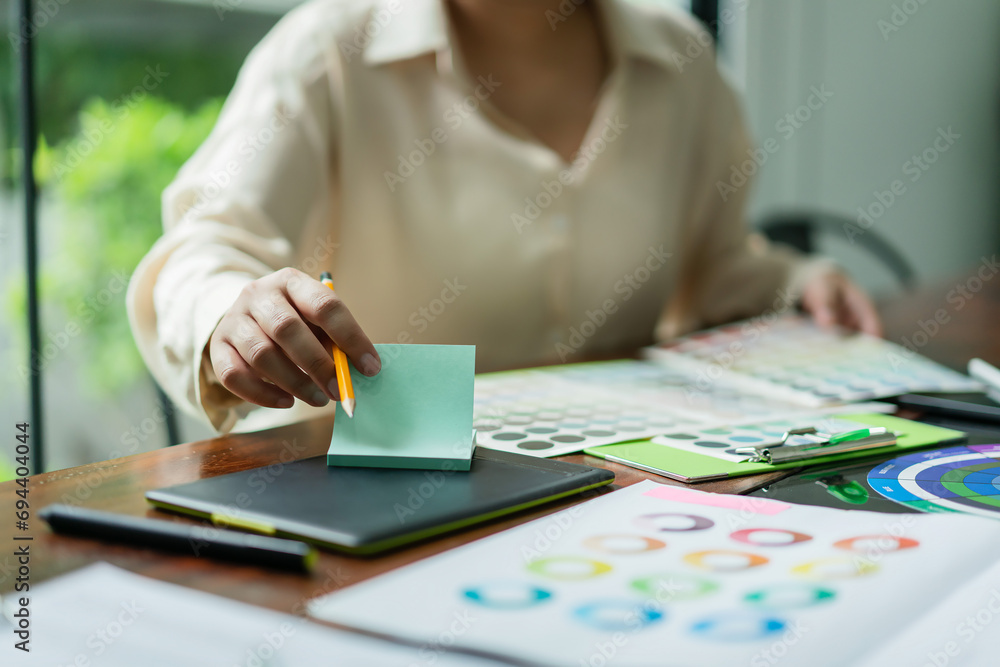Poster creative graphic designer choosing color on color swatch and writing notes idea in adhesive note