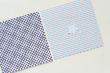 square paper tiles with plaid grid and stripes with small white star on blank paper