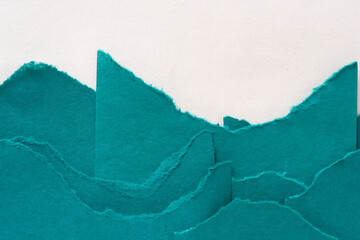 torn green paper layered at the bottom of a blank space for copy