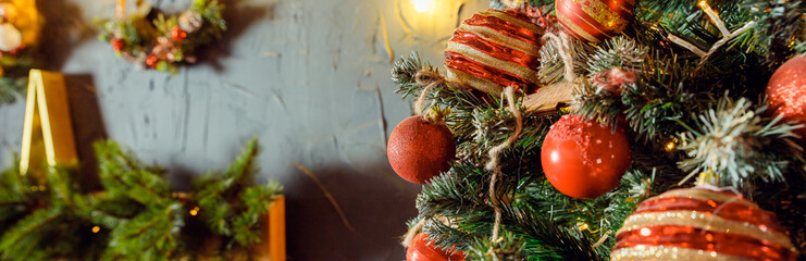 Christmas decorations on the holiday tree.Many colorful balls garland glowing lamps and red berries...