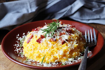Risotto with pumpkin and bacon on a dark wooden table. Top view