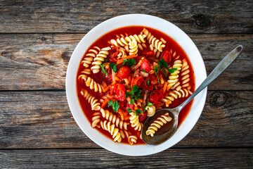 Tomato soup with noodles on wooden table
