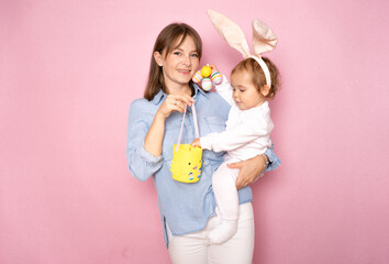 Mother, kid and spring basket, over pink background.