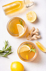 Preparation of refreshing kombucha with lemon and ginger, garnished with rosemary, flat lay,...